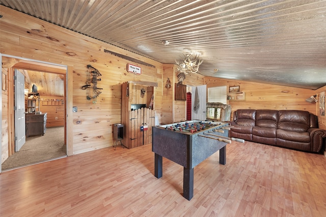 recreation room with vaulted ceiling, wooden walls, and hardwood / wood-style floors