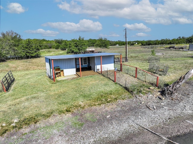 view of front of property with a front lawn, fence, and a rural view