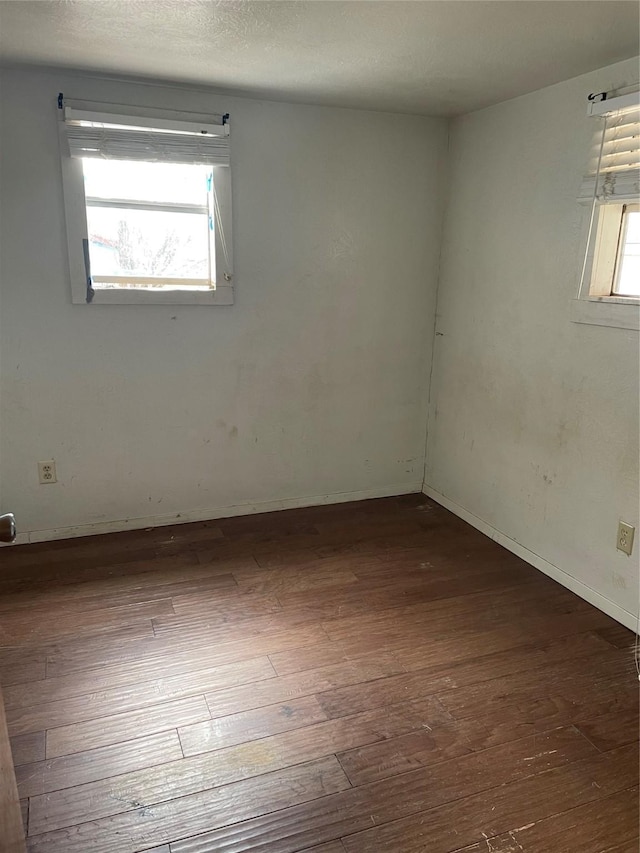 unfurnished room with dark hardwood / wood-style flooring