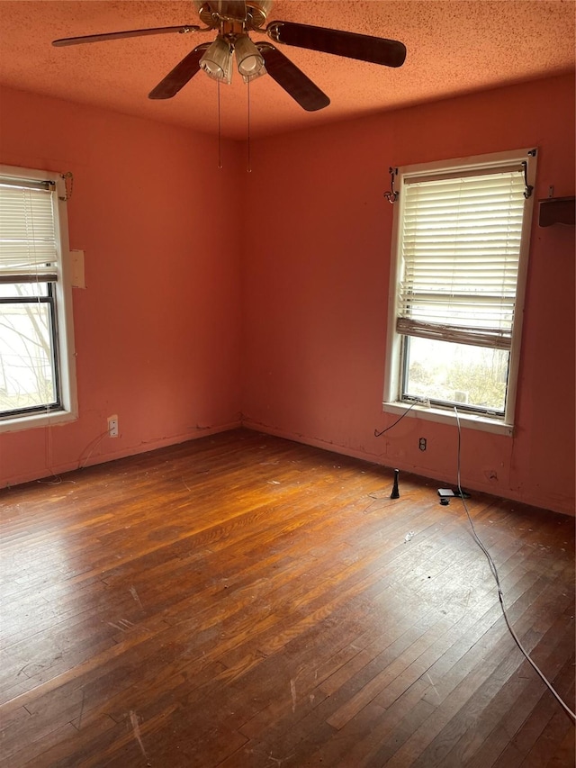 unfurnished room featuring ceiling fan, hardwood / wood-style floors, and a textured ceiling