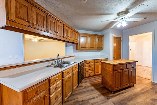 kitchen with hardwood / wood-style flooring, a textured ceiling, dishwasher, and a kitchen island