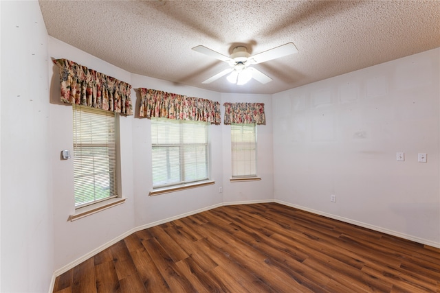 unfurnished room featuring plenty of natural light, ceiling fan, a textured ceiling, and dark hardwood / wood-style flooring