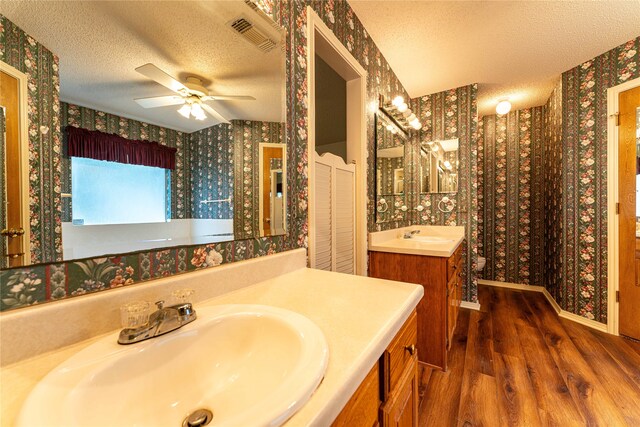 bathroom featuring vanity, a textured ceiling, hardwood / wood-style flooring, and ceiling fan