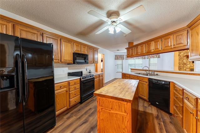 kitchen with dark hardwood / wood-style floors, wood counters, black appliances, and a kitchen island