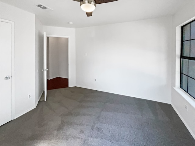 empty room with dark carpet and ceiling fan