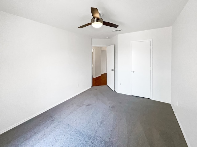 unfurnished bedroom featuring ceiling fan and dark carpet