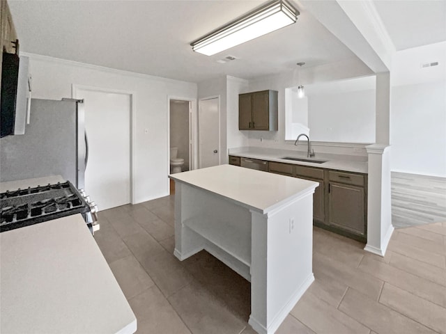 5103 Whitehaven Dr, Garland, TX 75043 - kitchen with a sink, appliances with stainless steel finishes, light countertops, light tile patterned flooring, and a center island