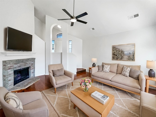 living room featuring vaulted ceiling, a brick fireplace, hardwood / wood-style flooring, and ceiling fan