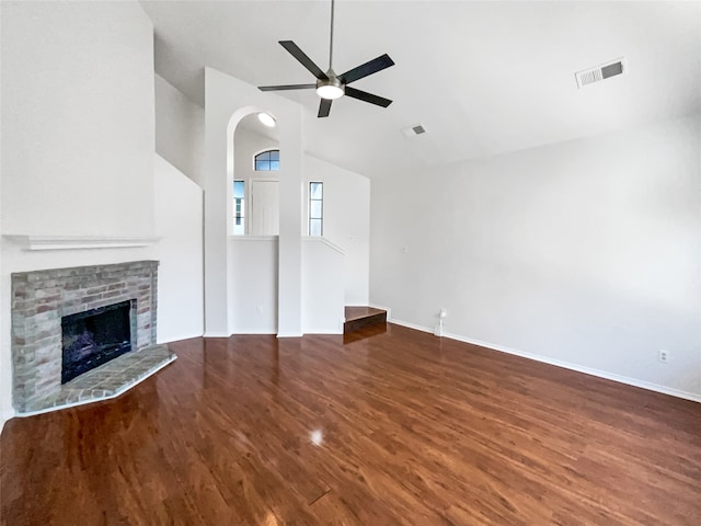 unfurnished living room with lofted ceiling, hardwood / wood-style floors, a brick fireplace, and ceiling fan