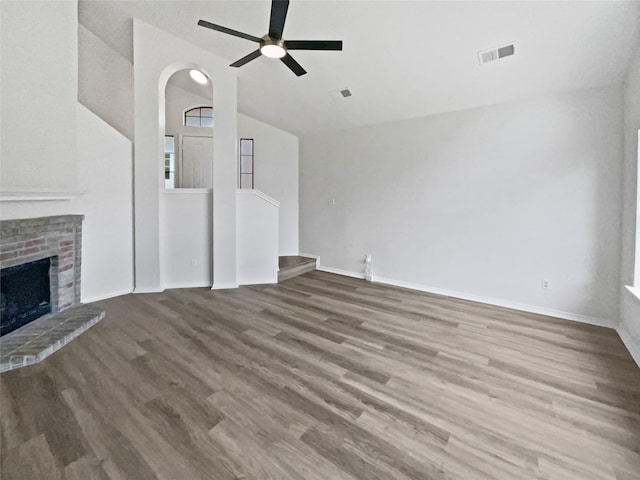5103 Whitehaven Dr, Garland, TX 75043 - unfurnished living room with vaulted ceiling, wood finished floors, ceiling fan, a brick fireplace, and baseboards