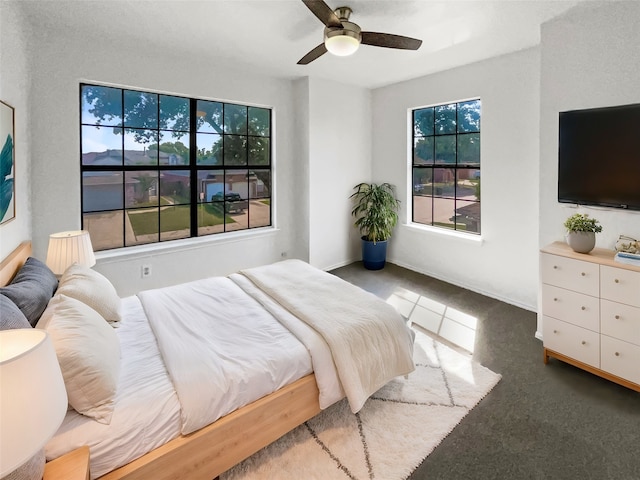 bedroom with ceiling fan, carpet flooring, and multiple windows