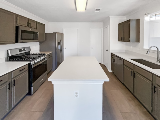 kitchen with light hardwood / wood-style flooring, appliances with stainless steel finishes, sink, and a kitchen island