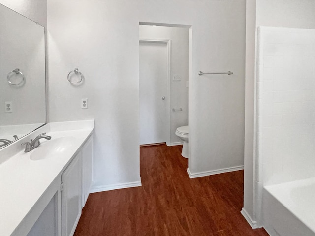 5103 Whitehaven Dr, Garland, TX 75043 - full bathroom featuring baseboards, toilet, wood finished floors, a tub, and vanity
