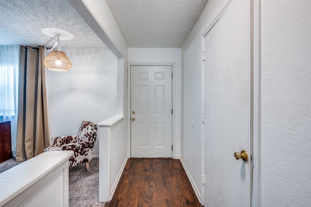 hallway featuring a textured ceiling and dark hardwood / wood-style flooring