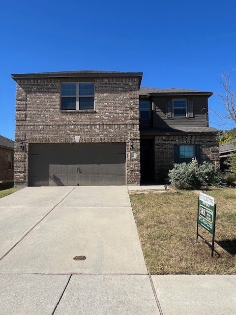 view of front of house with a garage and a front lawn