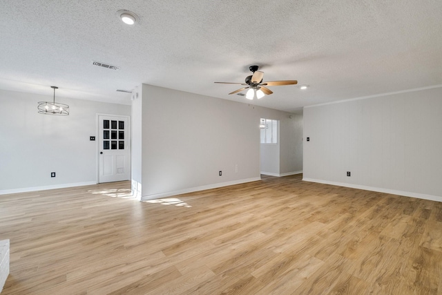 unfurnished room with ceiling fan with notable chandelier, light wood-type flooring, and a textured ceiling