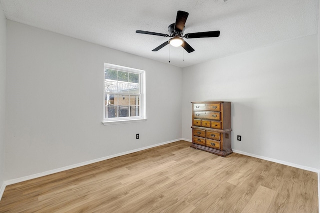 spare room featuring ceiling fan, light hardwood / wood-style flooring, and a textured ceiling