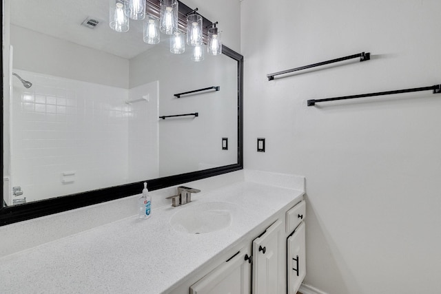 bathroom featuring vanity and tiled shower