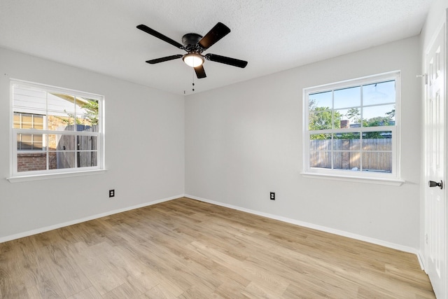 empty room featuring ceiling fan, light hardwood / wood-style floors, and a textured ceiling