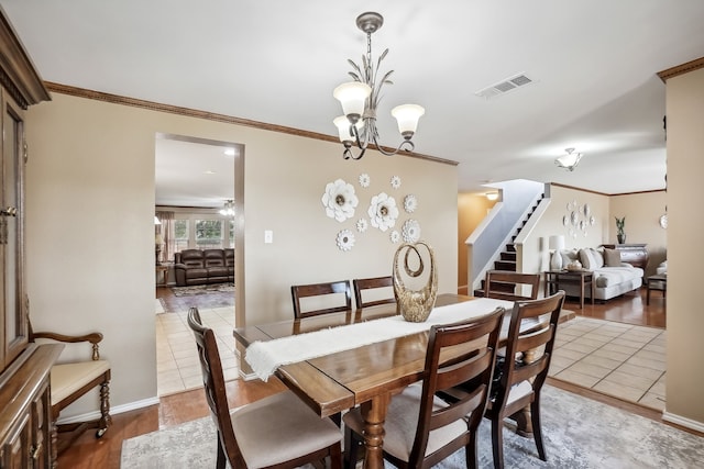 dining space featuring crown molding, an inviting chandelier, and hardwood / wood-style floors