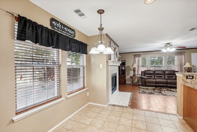 kitchen with hanging light fixtures, ceiling fan with notable chandelier, and light hardwood / wood-style floors