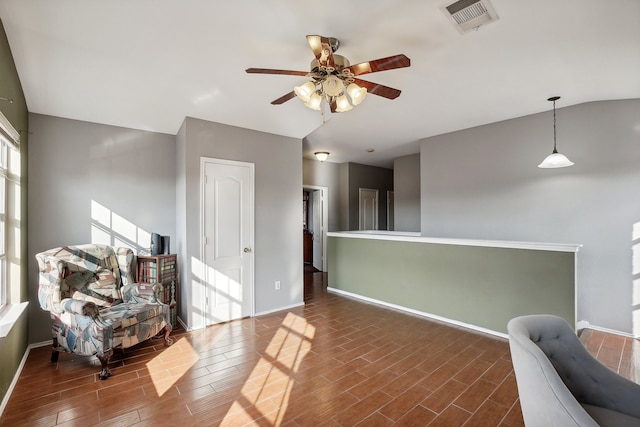 living area featuring dark hardwood / wood-style floors and ceiling fan