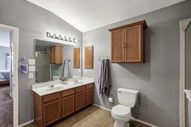 bathroom featuring lofted ceiling, a shower with door, toilet, vanity, and tile patterned flooring