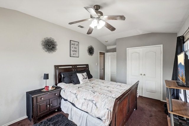 bedroom with dark carpet, lofted ceiling, a closet, and ceiling fan