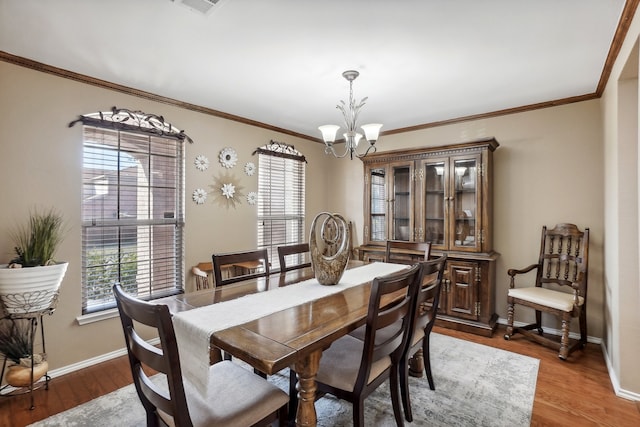 dining room featuring a notable chandelier, wood-type flooring, and crown molding