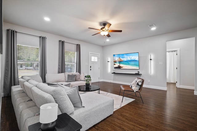 living room featuring dark wood-type flooring and ceiling fan