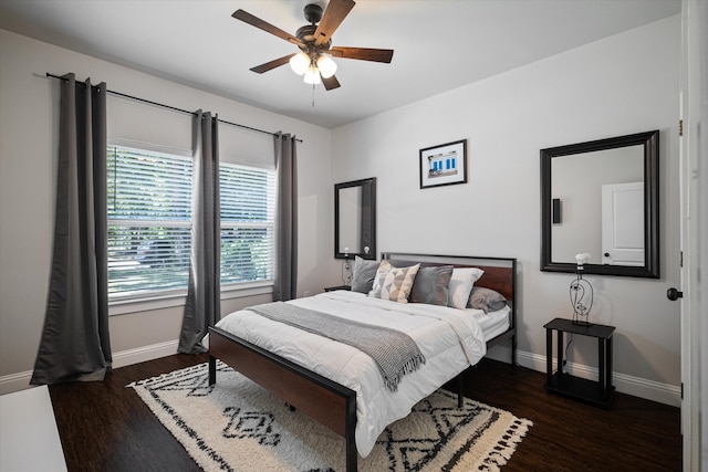 bedroom with dark hardwood / wood-style flooring and ceiling fan