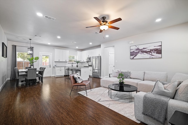 living room featuring sink, wood-type flooring, and ceiling fan