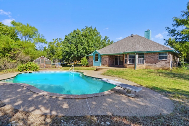 view of pool with a patio, a diving board, and a lawn