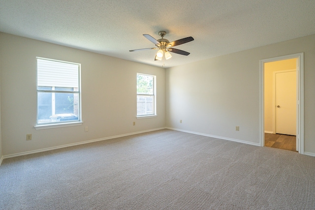 unfurnished room featuring a textured ceiling, light colored carpet, and ceiling fan