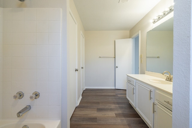 bathroom with vanity, hardwood / wood-style floors, and bathing tub / shower combination