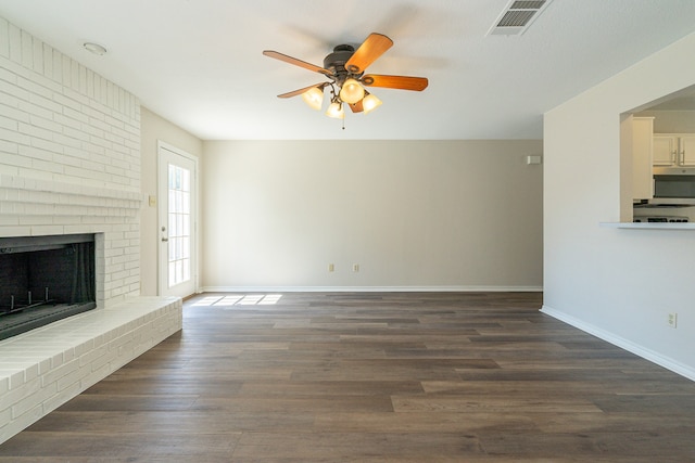 unfurnished living room featuring ceiling fan, a fireplace, and dark hardwood / wood-style floors