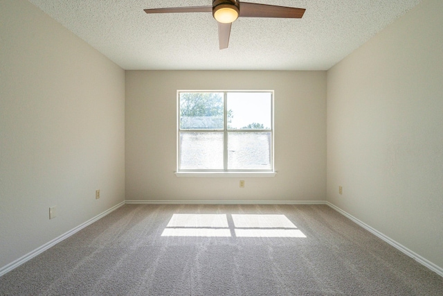 carpeted spare room with a ceiling fan, baseboards, and a textured ceiling