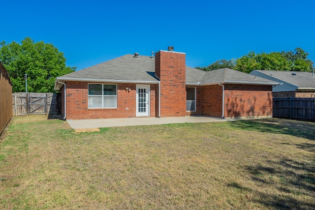 rear view of property with a yard and a patio