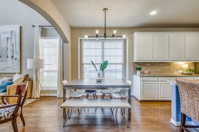 dining space with light hardwood / wood-style flooring and an inviting chandelier