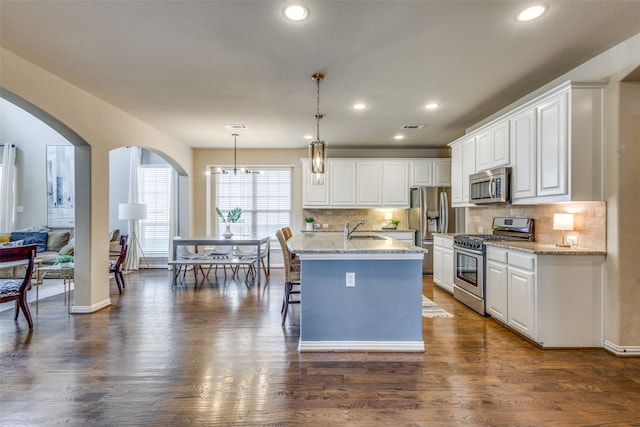 kitchen featuring stainless steel appliances, sink, pendant lighting, and white cabinets