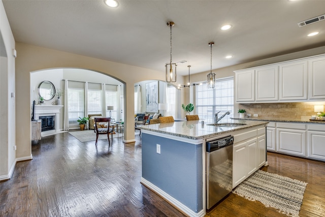 kitchen featuring plenty of natural light, dishwasher, an island with sink, and sink