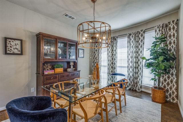 dining area featuring dark wood-type flooring and a notable chandelier