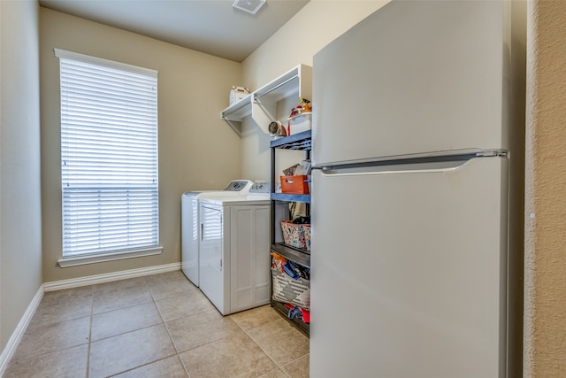 washroom with washer and dryer and light tile patterned flooring