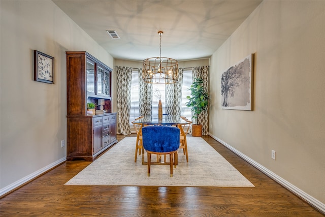 dining area with a notable chandelier and dark hardwood / wood-style flooring