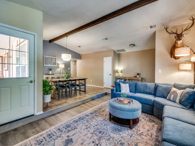 living area with wood finished floors, baseboards, and a textured ceiling