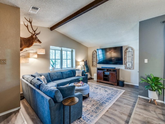 living area featuring a textured ceiling, wood finished floors, and baseboards