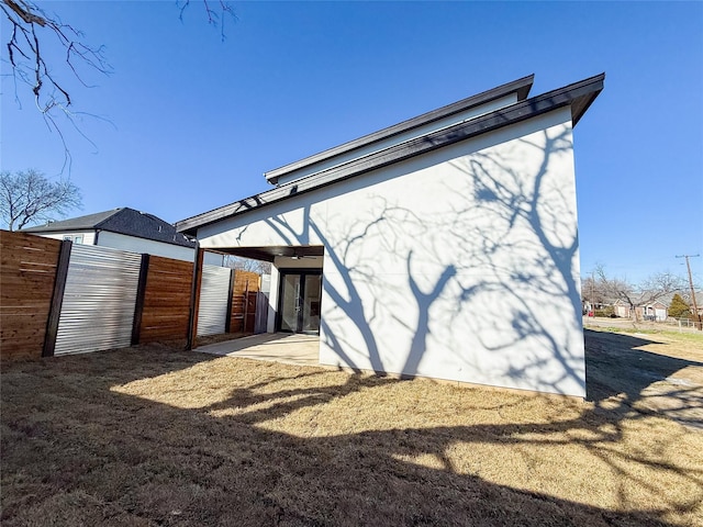 back of house featuring stucco siding and an outdoor structure