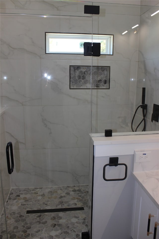 bathroom with a shower with door, plenty of natural light, and vanity