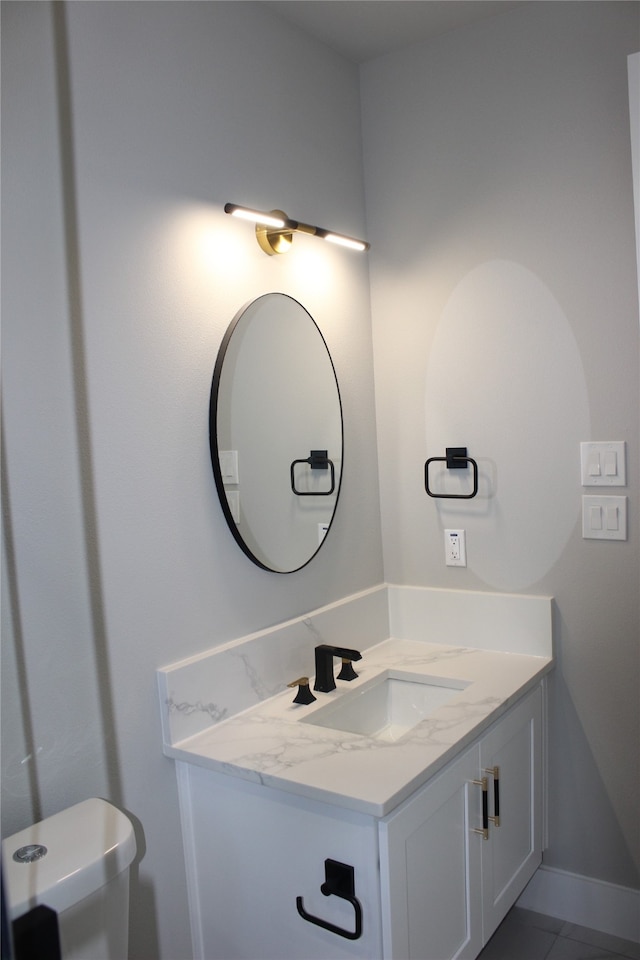 bathroom with vanity, toilet, and tile patterned floors