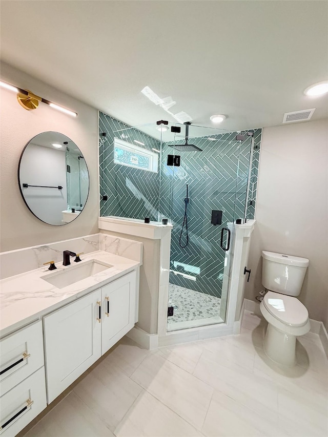 full bathroom with visible vents, toilet, a stall shower, vanity, and baseboards